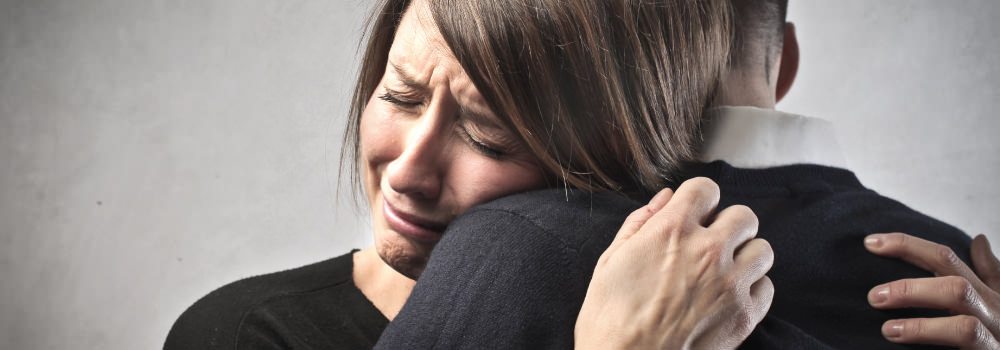 woman experiencing grief, hugging man